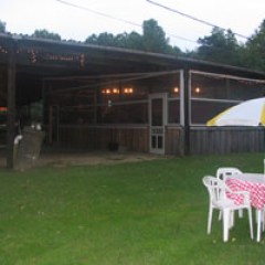a couple of lawn chairs sitting on top of a grass covered field