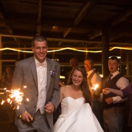 a group of people standing in front of a cake