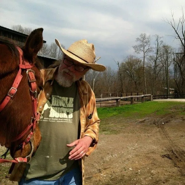 a man standing next to a horse