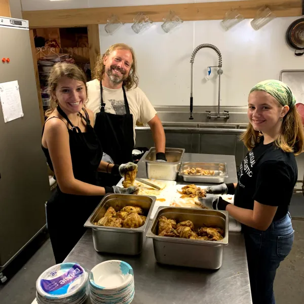 a woman standing in a kitchen preparing food